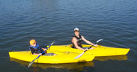 Photo of two children enjoying the water on their kayaks.